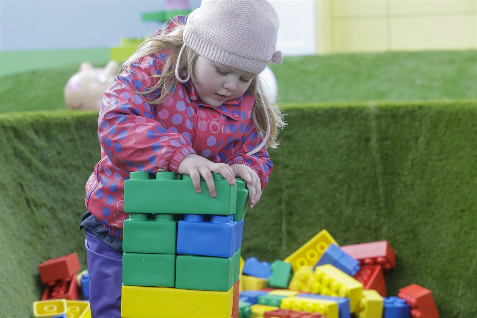 Lite barn stabler store LEGO DUPLO-klosser til et tårn i et lekeområde på Legoland Billund.
