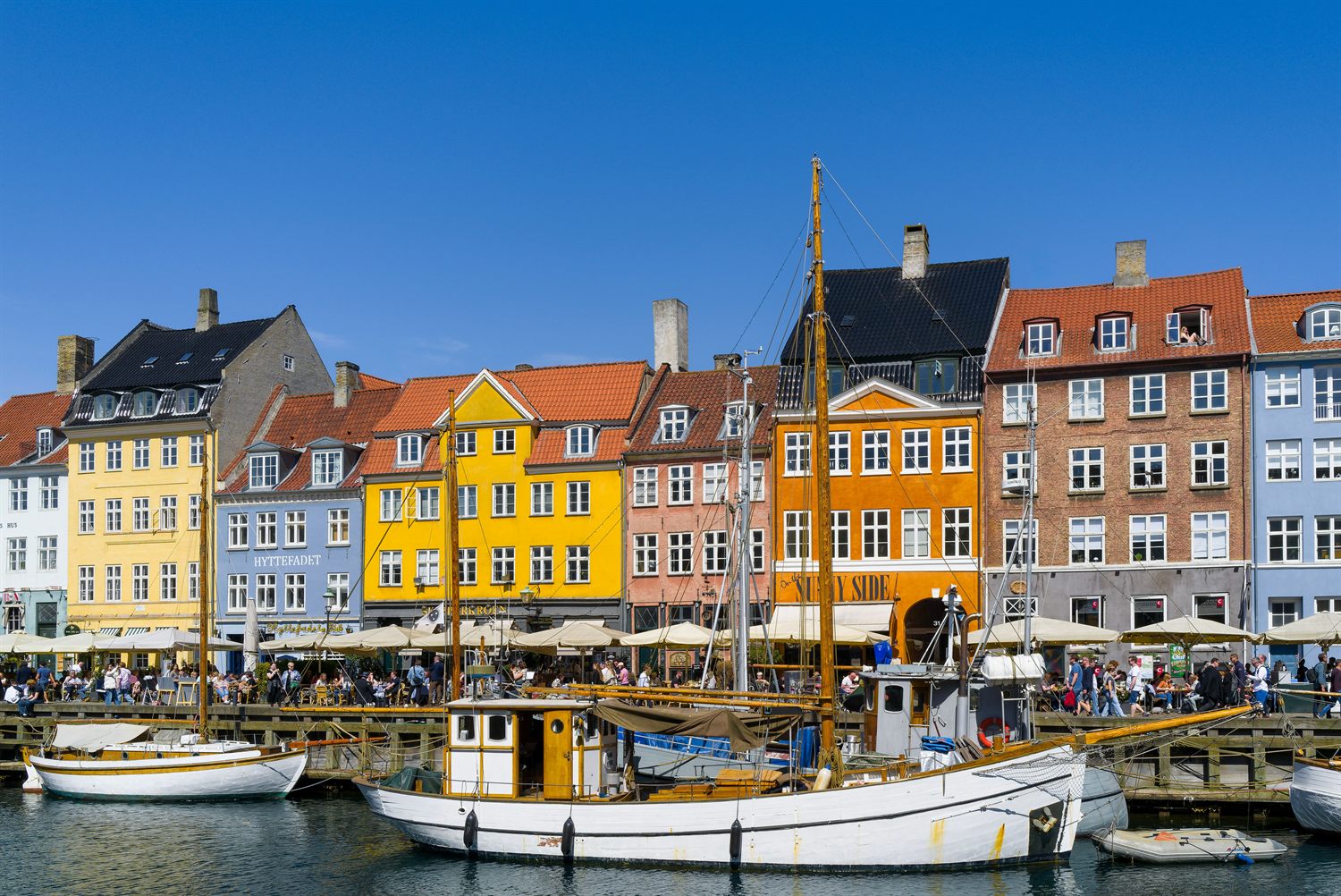Fargerike gamle hus og seilskuter langs kanalen i Nyhavn, København.