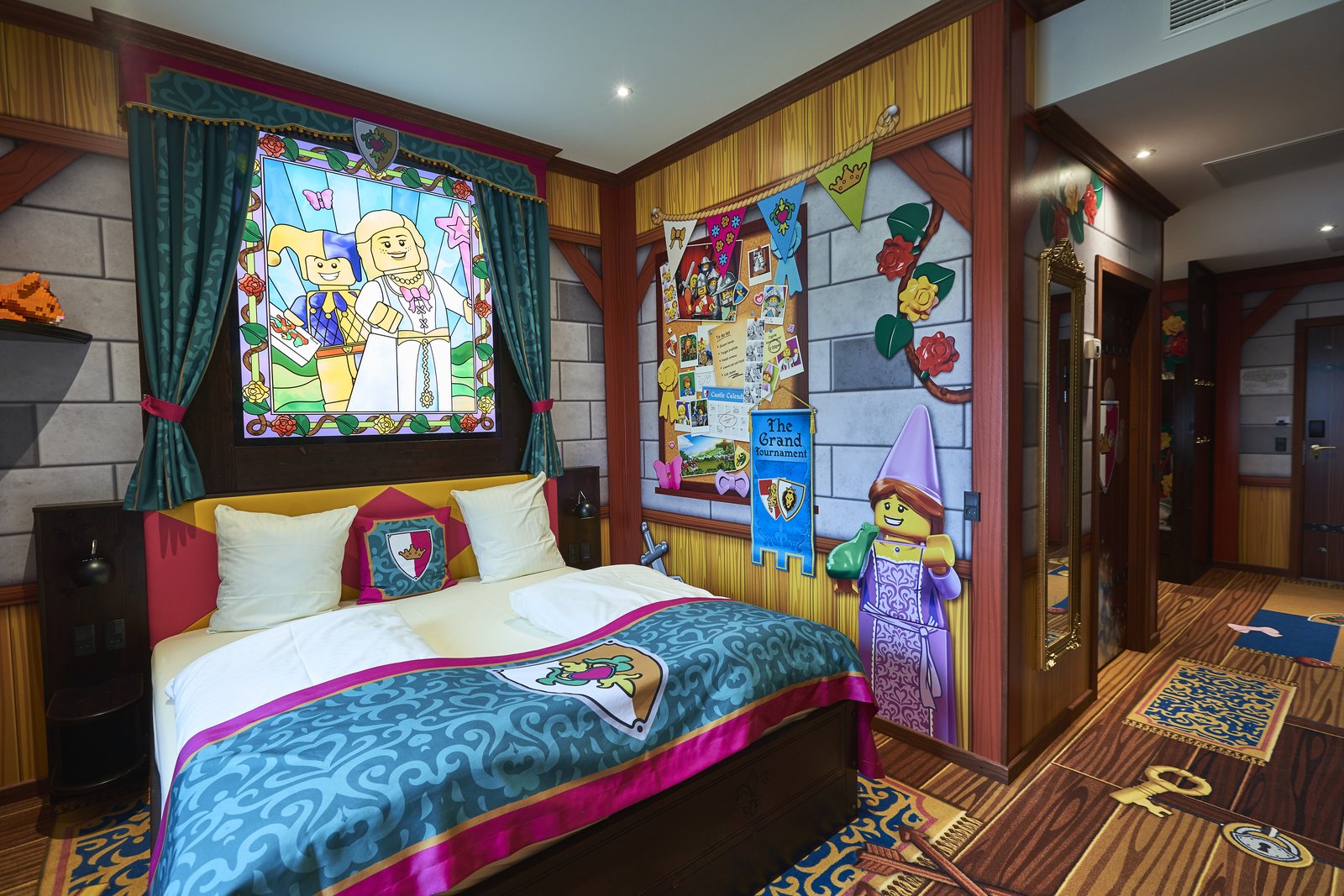 Prinsesserom på Castle Hotel med turkist og rosa sengetøy, glassmaleri med LEGO-prinsesse og blomstermotiv på veggene.